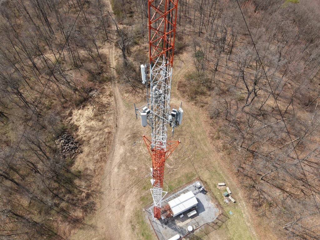 Drone view of a red and white lattice communications tower in New Jersey